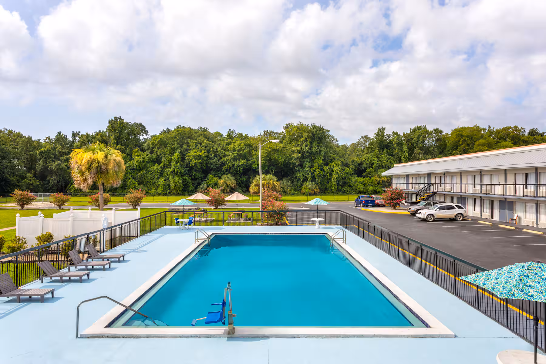 Outdoor heated pool with lounge chairs and palm trees